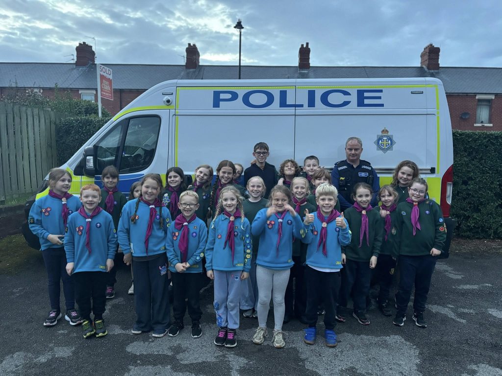 Group photograph of 1st Chilton Cubs and beavers and local PCSO stood infront of a police van