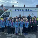 Group photograph of 1st Chilton Cubs and beavers and local PCSO stood infront of a police van